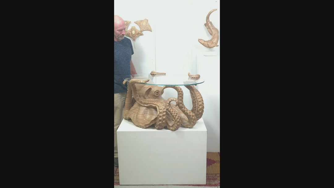 Hand-carved birch plywood octopus coffee table by Bill Prickett with sculptural tentacles supporting a low iron toughened glass top, combining functional furniture with detailed contemporary wood sculpture.