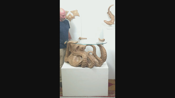 Hand-carved birch plywood octopus coffee table by Bill Prickett with sculptural tentacles supporting a low iron toughened glass top, combining functional furniture with detailed contemporary wood sculpture.