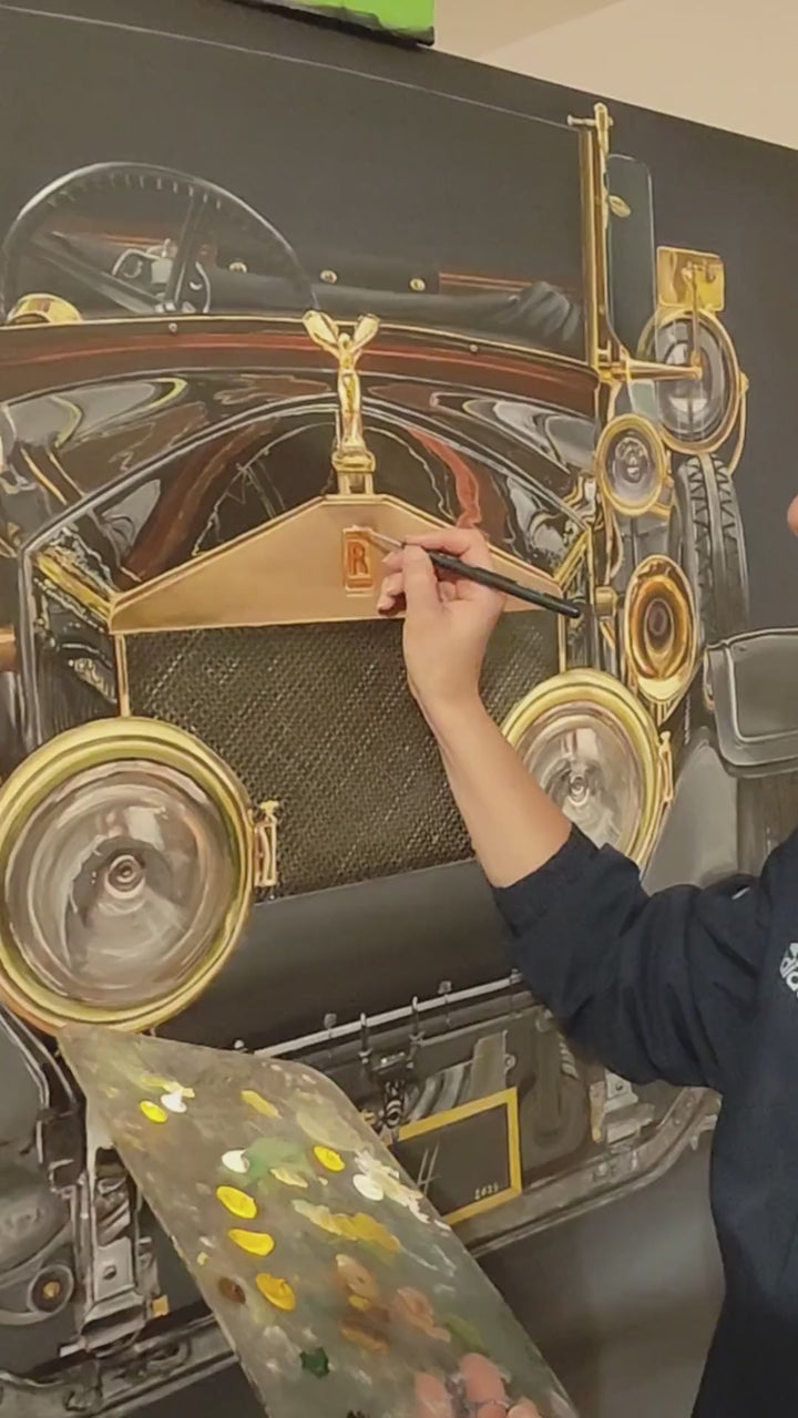 Video Hyperrealistic painting of a vintage Rolls-Royce viewed head-on, bathed in dramatic golden highlights against a deep black background. The iconic Spirit of Ecstasy hood ornament crowns the polished brass grille, flanked by ornate circular headlights and intricate mechanical details. The symmetrical, imposing composition transforms the car into a symbol of luxury, heritage, and cultural grandeur.