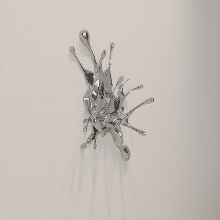 Wall-mounted stainless steel sculpture resembling a dynamic liquid splash frozen mid-motion, with high-shine chrome finish and flowing, organic extensions.