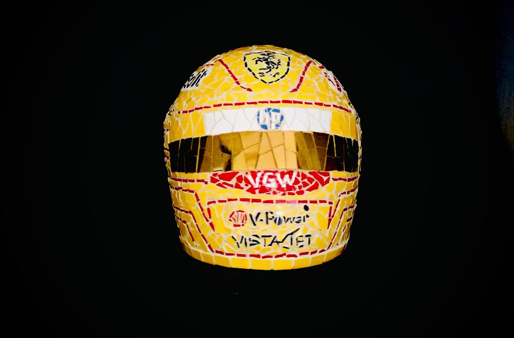 Full-size Ferrari-inspired Formula 1 helmet mosaic sculpture, handcrafted from individually cut ceramic tiles in red, yellow, white, black, and metallic gold. This bespoke artwork captures the energy and precision of motorsport design, created as an example of a custom commission.
