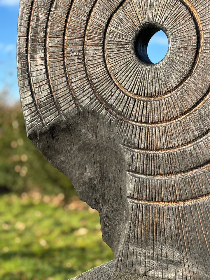 Charred oak sculpture by Glen Farrelly titled Ritual, carved with concentric cup and ring markings around a central void. Blackened Yakisugi surface contrasts with golden highlights, evoking ancient standing stones and ritual energy.