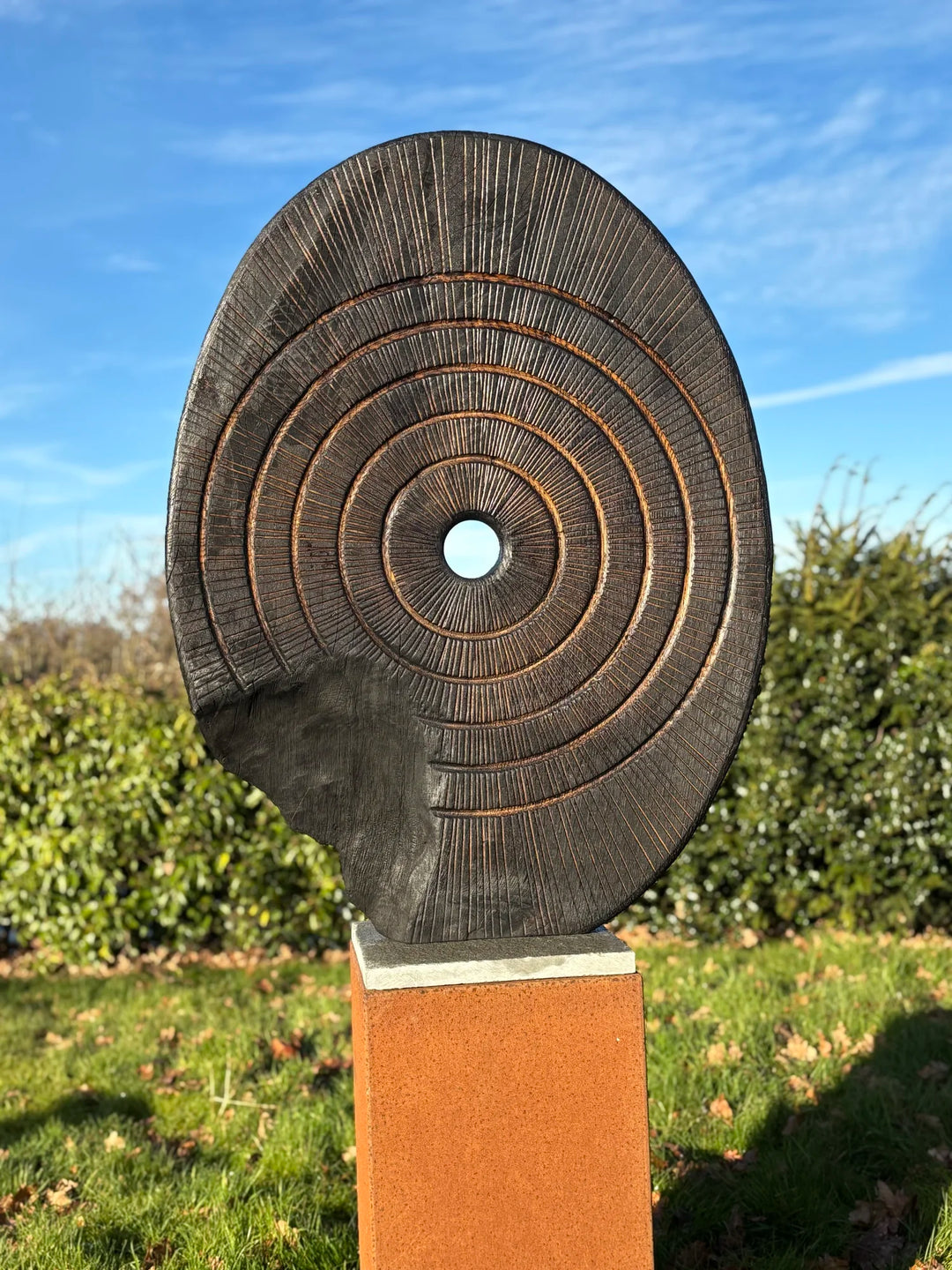 Charred oak sculpture by Glen Farrelly titled Ritual, carved with concentric cup and ring markings around a central void. Blackened Yakisugi surface contrasts with golden highlights, evoking ancient standing stones and ritual energy.