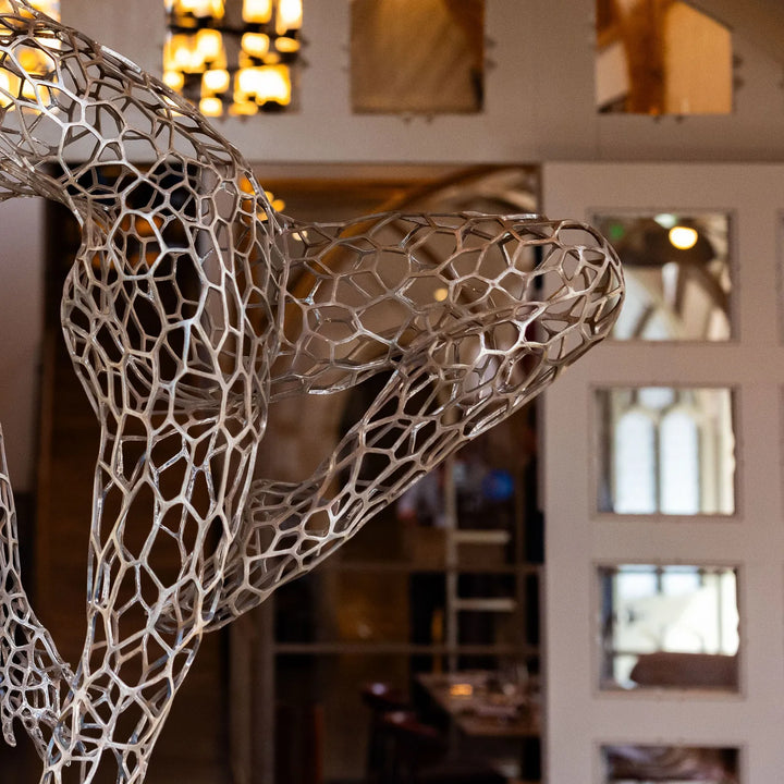 ‘Parallel Passé’ by Simon Gudgeon, a limited-edition figurative bronze sculpture inspired by Prima Ballerina Ksenia Ovsyanick. The life-size female dancer is captured en pointe in an elegant, dynamic ballet pose, formed through an intricate open Voronoi lattice that allows light and the surrounding environment to pass through and transform the sculpture.