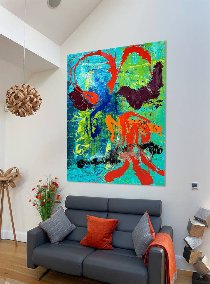 Large abstract painting “Infinite Light” by Swarez — vibrant sweeping strokes of scarlet red, fiery orange and deep burgundy layered over a luminous turquoise and lime green base, with accents of cobalt blue and black. Highly textured enamel surface with bold movement and glossy, light-catching details.