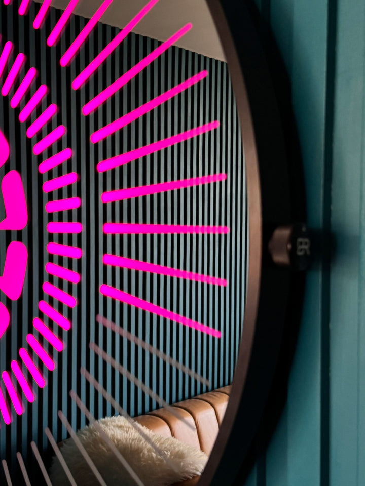 “Tempus Obsidian” by Ben Rousseau – a limited-edition illuminated wall timepiece crafted from grey mirrored glass and brass-tinted aluminium with LEDs. Inspired by obsidian, it radiates calm through subtle light and refined design.

