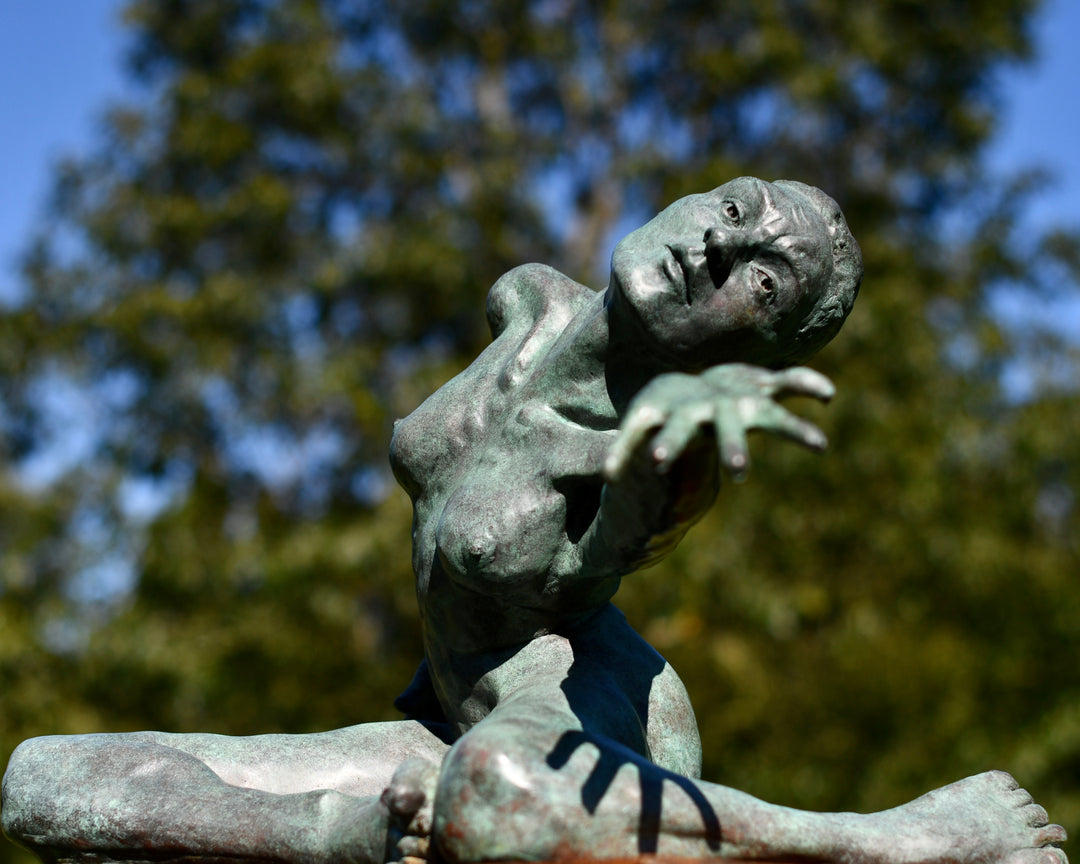 Teresa Wells’ The Wish (2021), limited edition bronze sculpture depicting a seated female figure with one leg folded beneath her and the other extended, torso twisting as she reaches outward with an expressive, outstretched hand. Finished in a mottled green patina with bronze undertones, the piece captures a moment of yearning and emotional intensity, with finely rendered musculature, detailed facial features, and dynamic posture. Measuring 60cm × 37cm × 44cm and weighing 37.3kg.