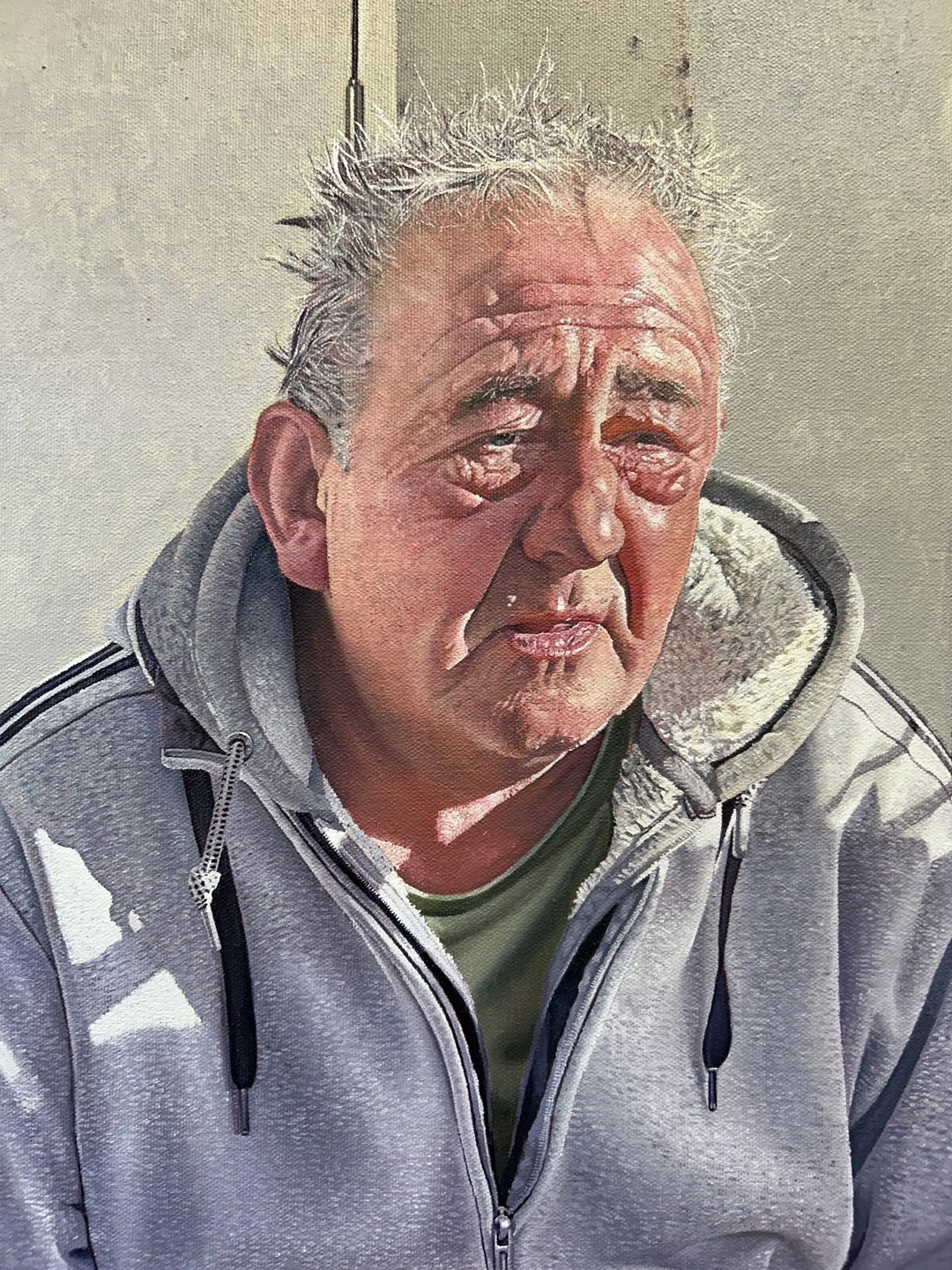 Original hyperrealist oil painting depicting two men seated side by side on a stone step in an urban doorway, capturing friendship, resilience, and quiet solidarity. Sunlight highlights weathered faces, worn clothing, and subtle gestures, conveying compassion, hardship, and human connection within a contemporary street setting.